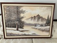 Full view of framed winter landscape painting on couch