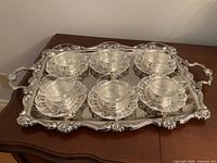 Tray with six cup holders, saucers and glass liners displayed