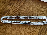 Entire triple-strand necklace coiled to show full length