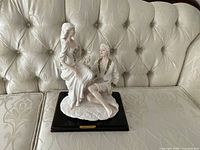 Full view of resin sculpture on couch showing overall form and base