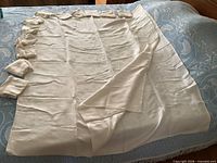 Tablecloth laid out on bed with stacked napkins