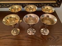 Front view of all six coupes showing gold-tone bowls and silver stems