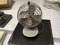 Front view showing four blades, wire cage and base