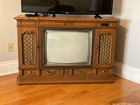 Front view showing CRT screen, wood cabinet, lattice speaker panels