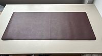 Full view of brown desk pad on white table