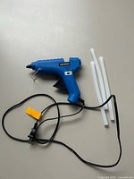 Full lot view showing glue gun with cord and three glue sticks