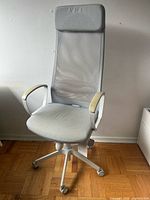 Front view of light gray mesh office chair showing headrest, seat, armrests, and five-star base