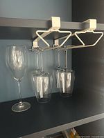 Racks installed under shelf holding glasses