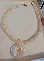 Full view of woven freshwater pearl necklace with shell pendant and clasp