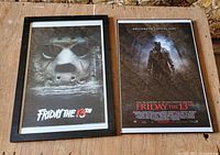 Both framed posters side by side on table