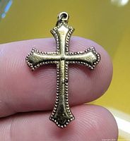 Front view of gold filled cross pendant showing bead edging and bail