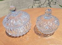 Both crystal candy dishes with lids shown together