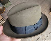 Side view of dark olive Knox felt fedora with black grosgrain ribbon and upturned brim