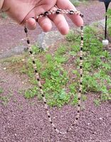 Full view of magnetic bead necklace showing alternating black magnet beads and metallic seed beads