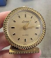 Front view of brass-tone Linden alarm clock showing dial and bezel