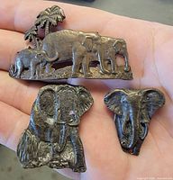 All three metal elephant magnets shown on palm for scale