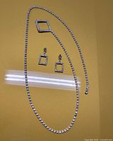 Belt laid out showing full length and earrings positioned beside it