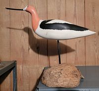 Full side view of carved avocet decoy on driftwood base