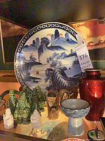 Overall view of plate, red vase, bowl, figurines