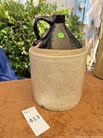 Full view of beige stoneware jug with dark glazed top