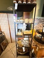 Full view of tall black metal shelving unit with four shelves