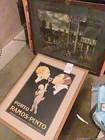 Two framed pieces; lot item is the upper framed village scene poster