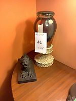 Glass urn on ornate base with foo lion figure