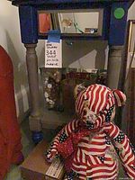 Accent side table, glass cylinder with ornaments beneath, patriotic teddy bear in front