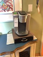 Front and side view of Keurig brewer on pod drawer
