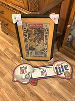 Framed Daily News front page and Miller Lite NFL sign together