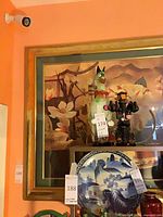 Front view showing framed art print behind other objects