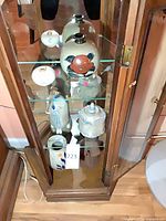 All six ceramic pieces displayed in glass cabinet