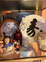 Group view of assorted porcelain items on shelf