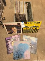 Milk crate filled with records; Robert Palmer, Men at Work, MCA Disco, Pink Floyd, The Who jackets displayed