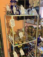 Full view of white metal glass shelf with four tiers
