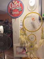 Overall view of metal sign, dreamcatcher and framed print hanging on wall