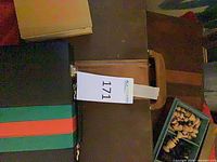Brown case with black exterior, green/red stripes and contents partially visible