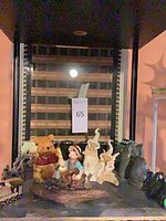 Shelf view showing Pooh, boy figurine, abstract pieces and miniatures