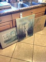 All three wall-decor pieces leaning against cabinets