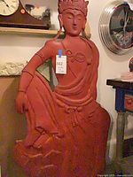 Full view of red concrete Buddha statue