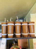 Six rhinestone football tumblers standing on shelf