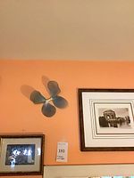 Framed print, smaller framed print beneath, metal wall sculpture to left