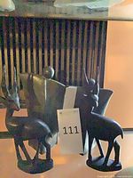 Group view of all four wooden sculptures: two antelopes and two abstract figures