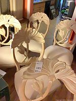 Group of six matching carved floral back dining chairs with cream upholstery