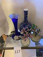 Both blue/gold vases and two artificial plants on shelf