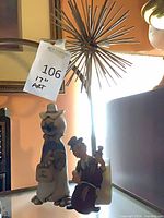 Group shot showing both ceramic figurines and metal starburst sculpture
