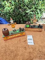 Both Trick Dog mechanical banks side by side