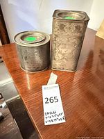 Rectangular and cylindrical silver-plated canisters on table with size note visible