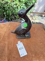 Full view left side of cast iron duck statue on base