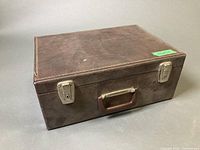 Closed brown leather case with handle and latches visible
